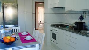 eine Küche mit einem Tisch mit einer Obstschale darauf in der Unterkunft Spacious Apartment in Armação de Pêra with Sea View - 90 m² in Armação de Pêra