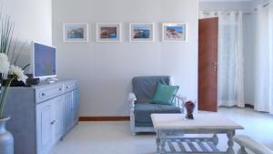 ein Wohnzimmer mit einem Stuhl und einem Tisch in der Unterkunft Spacious Apartment in Armação de Pêra with Sea View - 90 m² in Armação de Pêra