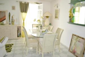 a dining room with a table and chairs at Location spacieuse à Deshaies avec vue sur la mer et montagne in Deshaies