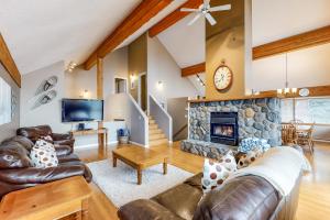 sala de estar con muebles de cuero y chimenea de piedra. en Powder Paradise, en Big White