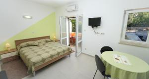 1 dormitorio con cama, mesa y TV en Sunrise Apartments 2, en Cavtat