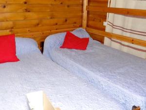 two beds with red pillows in a room at Maison de 2 chambres avec vue sur la ville et jardin a Loudenvielle a 5 km des pistes in Loudenvielle
