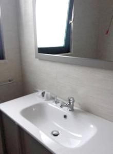 a bathroom with a white sink and a mirror at Cosy Apartment in Carovigno, 40 sqm with Garden in Carovigno