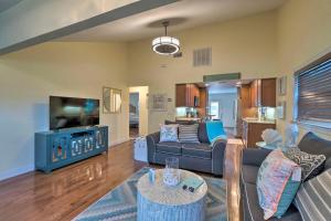 a living room with couches and a flat screen tv at Bright Sarasota Bungalow - 5 Mi to Siesta Beach! in Sarasota