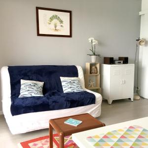 uma sala de estar com um sofá com um cobertor azul em Appartement d'une chambre a Guerande a 600 m de la plage avec vue sur la mer piscine partagee et jardin clos em Guérande