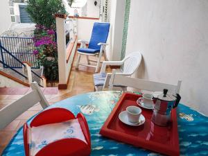 una mesa con dos sillas y una bandeja con tazas. en One bedroom appartement at Alcamo 200 m away from the beach with furnished balcony, en Alcamo