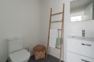 a bathroom with a toilet and a ladder next to a sink at Royal Flats in Las Palmas de Gran Canaria +37 photos