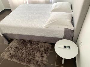 a small bedroom with a bed with a white table at Appartement confortable au Moule 60 m² avec piscine privée in Le Moule +17 photos
