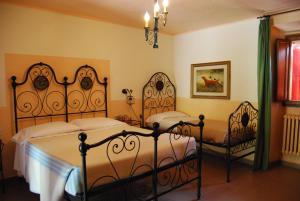 1 dormitorio con 2 camas y 2 sillas en Agriturismo Badia di Susinana, en Palazzuolo sul Senio