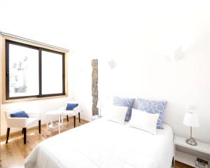 a white bedroom with a bed and a window at Spacious House in Porto + Garden in Porto