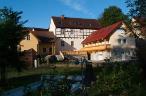 ein großes Gebäude mit rotem Dach im Hof in der Unterkunft Landhotel Altes Pfarrhaus in Bilzingsleben