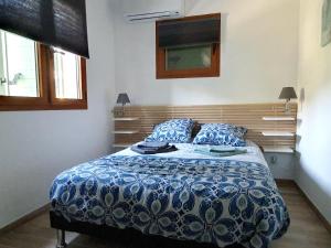 una camera con un letto e un piumone blu e bianco di Maison de 3 chambres avec terrasse amenagee et wifi a Esparron de Verdon a Esparron-de-Verdon