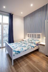 1 dormitorio con cama blanca y ventana en Victoria Apartment, en Gliwice