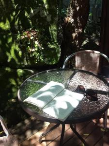 a glass table and chair on a patio at Pousada Piratas do Embaú in Guarda do Embaú
