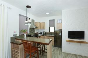 a kitchen with a table and chairs and a television at Studio with city view furnished terrace and wifi at Moka in Moka