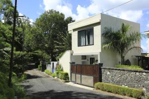 a white house with a fence and a stone wall at Studio with city view furnished terrace and wifi at Moka in Moka