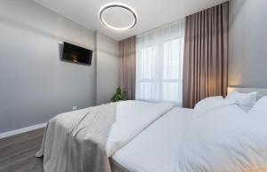 ein Schlafzimmer mit einem großen weißen Bett und einem Fenster in der Unterkunft Люкс в ЖК Лебединый, Харьковская, Позняки in Kiew