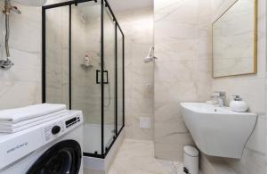 a bathroom with a washing machine and a sink at Люкс в ЖК Лебединый, Харьковская, Позняки in Kyiv +10 photos