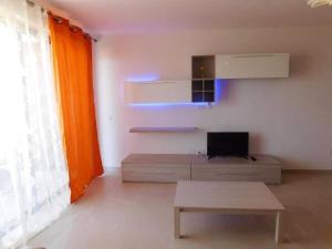 a living room with a couch and a tv at Bright apartment with sea view in Għajnsielem - 120 sqm in Għajnsielem