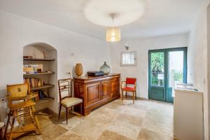 a living room with a table and chairs and a book shelf at Charmante Maison à Bonnieux avec Terrasse et Vue sur le Jardin in Bonnieux +13 photos