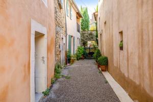 an alley way between two buildings with plants at Charmante Maison à Bonnieux avec Terrasse et Vue sur le Jardin in Bonnieux