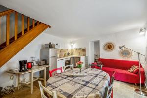 a living room with a table and a red couch at Charmante Maison à Bonnieux avec Terrasse et Vue sur le Jardin in Bonnieux