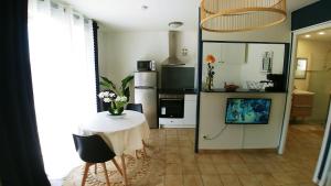 a living room with a table and a kitchen at Caroline in Oyonnax