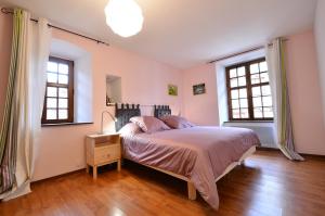 een slaapkamer met een bed en 2 ramen bij My Riquewihr in Riquewihr