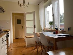 eine Küche mit einem Tisch und Stühlen sowie einem Fenster in der Unterkunft Hostel Czecha in Warschau