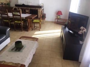 un soggiorno con tv e tavolo di Villa avec jardin à Poussan avec piscine privée ouverte toute l'année a Poussan