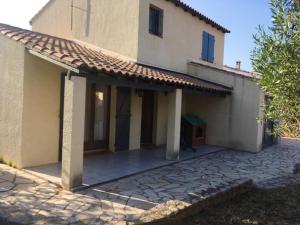 una vista esterna di una casa con patio di Villa avec jardin à Poussan avec piscine privée ouverte toute l'année a Poussan
