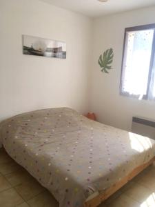 una camera da letto con letto con lenzuola a pois di Villa avec jardin à Poussan avec piscine privée ouverte toute l'année a Poussan Altre 25 foto