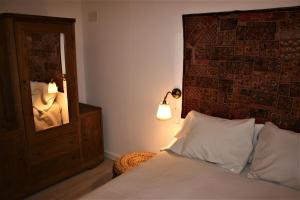 a bedroom with a bed with a mirror and a lamp at El Mirador de Casa Guareña in Villabáscones de Sotoscueva