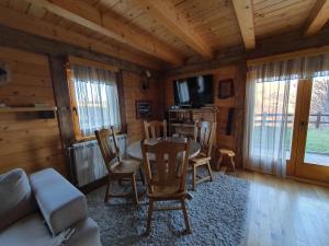 ein Wohnzimmer mit einem Tisch und Stühlen in einer Hütte in der Unterkunft Vila Dizdarevic Kopaonik in Kopaonik
