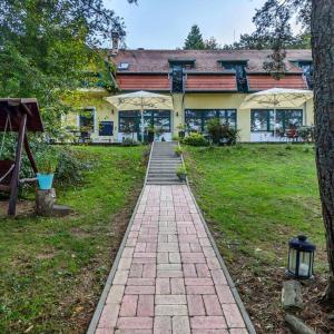 a brick walkway in front of a house at Apát Panzió és Étterem in Apátistvánfalva