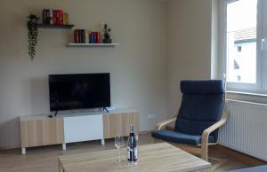 a living room with a television and a blue chair at Ferienwohnung am Hirschkopf in Baiersbronn
