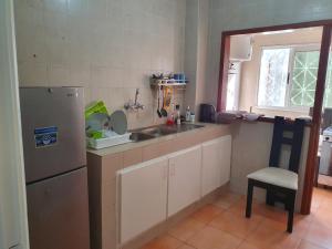 a small kitchen with a sink and a refrigerator at Appart Sly Abidjan in Cocody +12 photos
