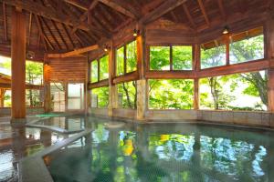 una piscina cubierta en una casa con ventanas en Kusatsu Onsen Boun, en Kusatsu