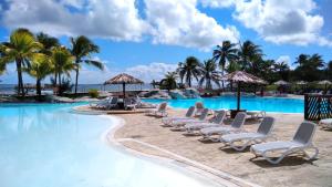 - une piscine avec des chaises longues et l'océan dans l'établissement Studio avec GRANDE PISCINE, PLAGE Vanille Caraïbes, à Saint-François