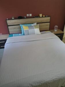 duże białe łóżko z poduszkami na górze w obiekcie Appart Sly Abidjan w mieście Cocody