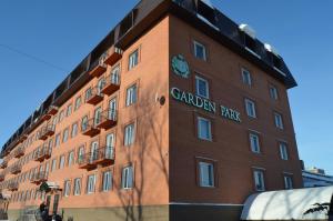 Um edifício de tijolos vermelhos com um sinal de parque canadiano. em Golden Park Hotel em Pavlodar