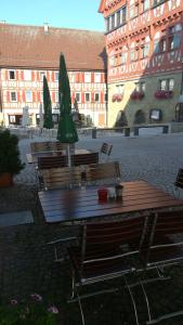 un groupe de tables et de chaises avec parasols dans une cour dans l'établissement Gasthof Stadtschänke, à Großbottwar