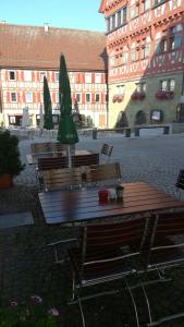 a group of tables and chairs with umbrellas in a courtyard at Gasthof Stadtschänke in Großbottwar