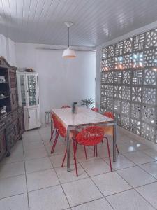 a dining room with a table and red chairs at 4ª Cia Hostel e Pousada in Fortaleza