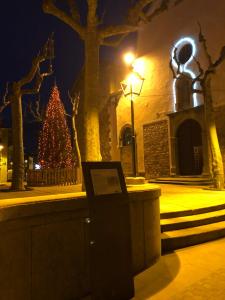 uma árvore de Natal em frente a um edifício à noite em Escloper B&B em Sant Juliá de Vilatorta