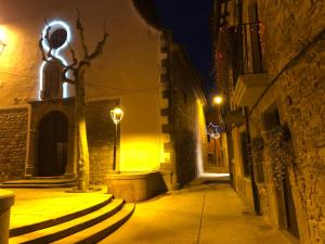 a statue of a man on a street at night at Escloper B&B in Sant Juliá de Vilatorta