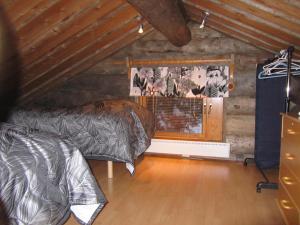 a bedroom with two beds and a wall with pictures at Rukakaiku Cottages in Ruka
