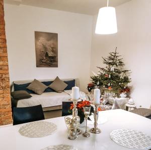 ein Wohnzimmer mit einem Tisch und einem Weihnachtsbaum in der Unterkunft Garden View Home in Mārupe