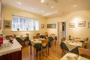 ein Restaurant mit Tischen und Stühlen und einem Fenster in der Unterkunft 9 Green Lane Bed and Breakfast in Buxton