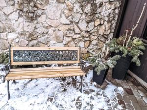 a wooden bench sitting in front of a stone wall at Garden View Home in Mārupe